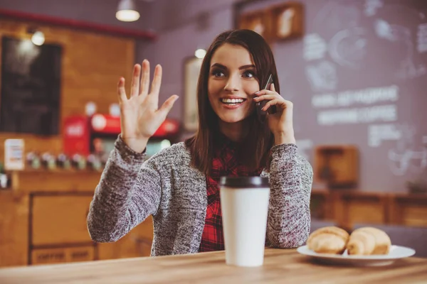 Jonge vrouw met mobile in café. — Stockfoto