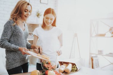 Anne ve kızı birlikte mutfakta yemek gülümseyerek. Aile ilişkisi var. Tatil evde. Sağlıklı gıda ve yaşam tarzı kavramı. Birlikte yemek. Aile kavramı mutluluk.