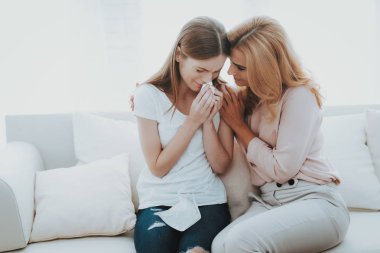 Kadın mutsuz genç kızı evde huzur veriyor. Evde kanepede oturan. Sorun olan kız. Aile çatışmada. Üst ve alt. Mutsuz kız. İletişim kavramı. İlişki kavramı.
