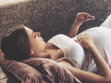 Güzel bir hamile kadın derece ölçme.