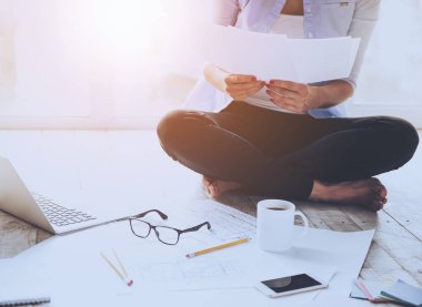 Genç kadın belgeleri okuma oturan kat.