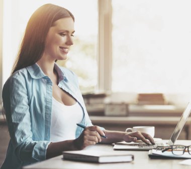 Gülümseyen hamile kadın evde laptop ile çalışma