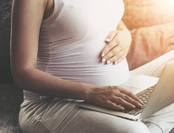 Pregnant Woman Using Laptop and Sitting on Sofa. — Stock Photo, Image