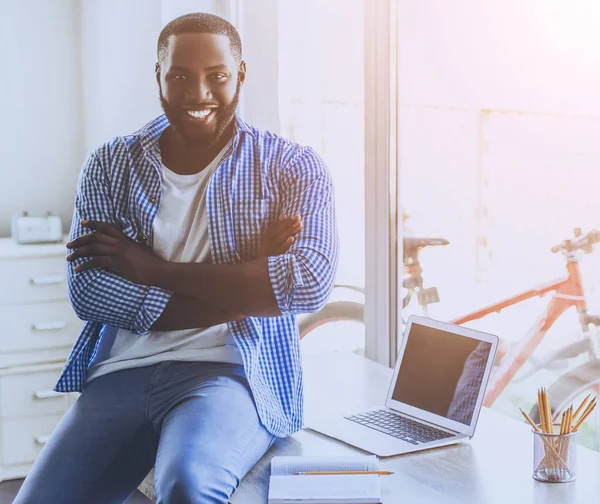 Beard ung Afro-american Man sitter på bord. — Stockfoto