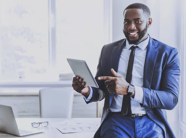 Hombre de negocios afroamericano guapo usando tableta . — Foto de Stock