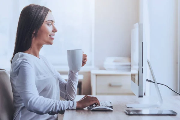 Femme utilisant un ordinateur et une tasse de maintien au bureau . — Photo