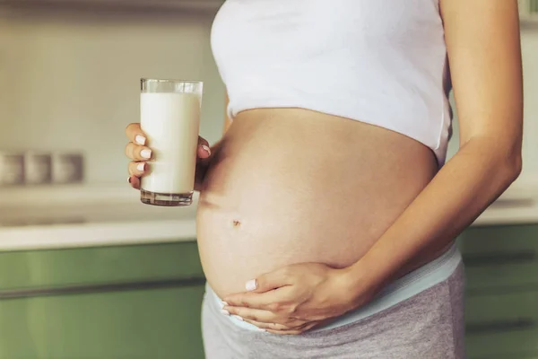 Schwangere hübsche Frau hält Glas Milch . — Stockfoto