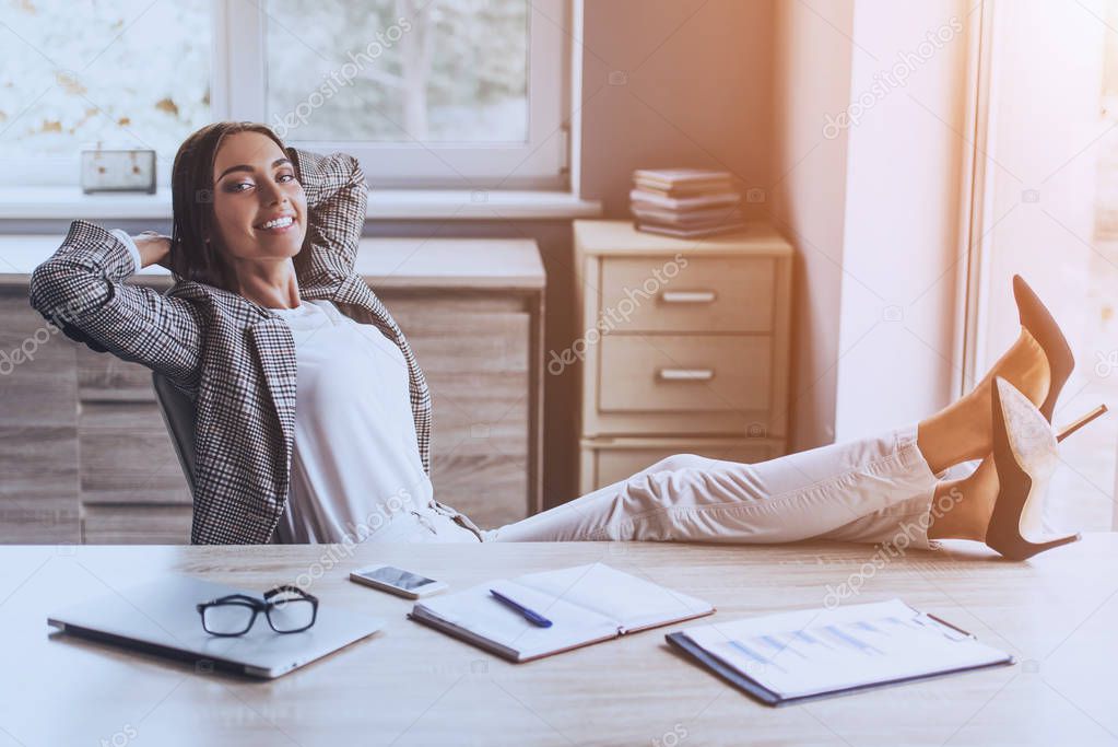 Pretty Business Lady Smiling and Sitting in Office