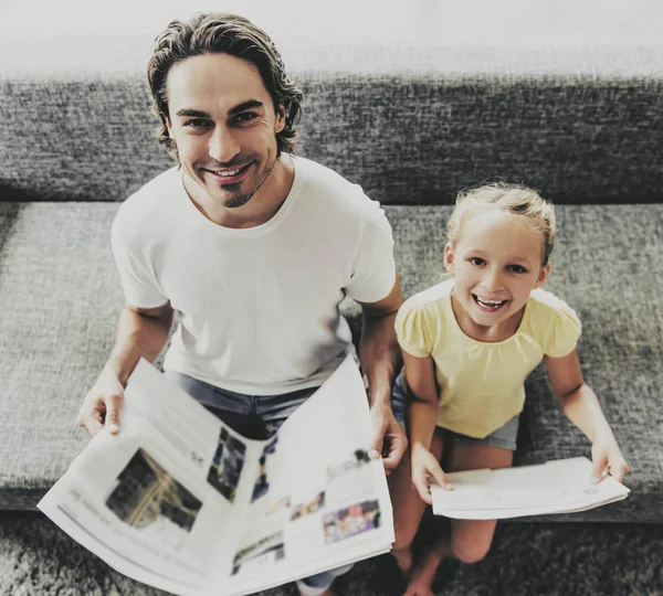 Pai e filha lendo jornais em casa . — Fotografia de Stock