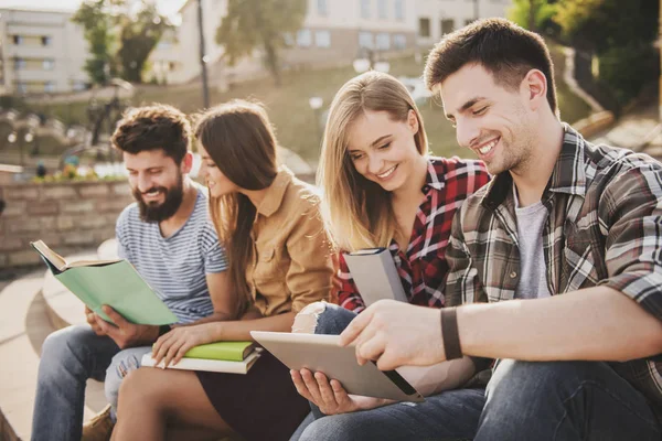 Park ve okumak kitap içinde oturan genç insanlar.