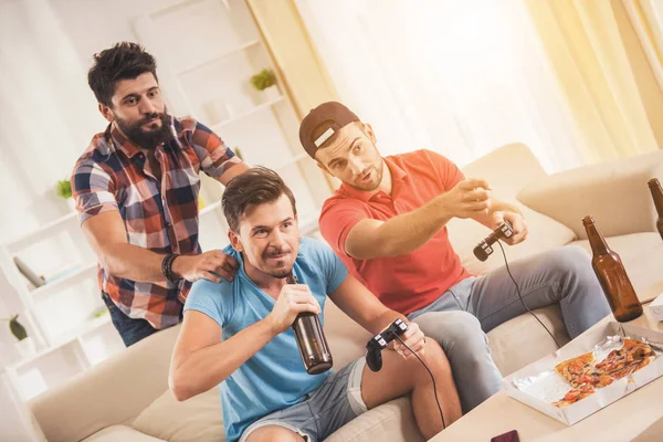 Trzech młodych mężczyzn szczęśliwy w domu grając w gry wideo. — Zdjęcie stockowe