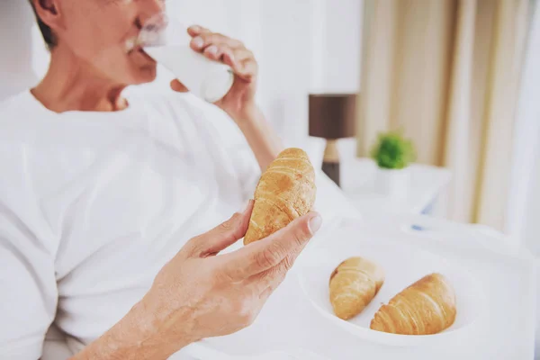 De cerca. Viejo desayunando en la cama en casa . — Foto de Stock