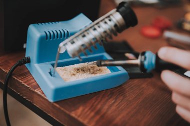 Yakın çekim. Lehimleme demir el ile genç adam.