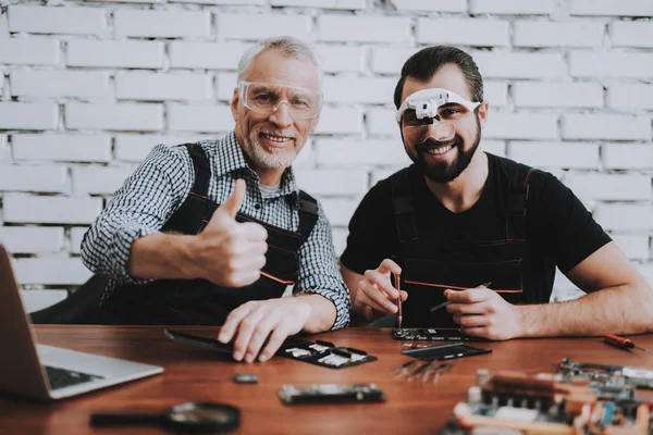 モダンなワーク ショップでの携帯電話の修理 人の男性 修理店 古い労働者 デジタル デバイス 眼鏡の男 電子機器のコンセプトです モバイル — ストック写真