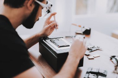 Genç tamir donanım ekipman tamircisi adam. Araçları ile çalışan. Bilgisayar donanım. Elektronik cihazlar kavramı. Sakallı adam Modern cihazlar. Dijital aygıt. Gözlüklü adam.