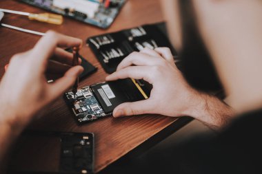 Kadar genç adam tamir cep telefonu masasında kapatın