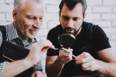 İki adam Pc. onarım donanım ekipmanları tamir dükkanı. Araçları ile çalışan. Bilgisayar donanım. Genç ve yaşlı işçi. Modern cihazlar. Dijital aygıt. Laptop üstünde okul sırası. Elektronik cihazlar kavramı.