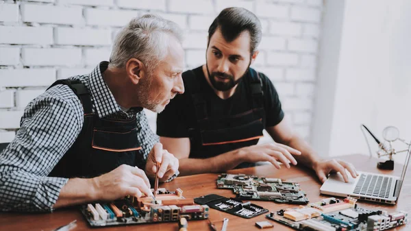 二人の男が 修理からハードウェア機器の修理店します ツールの労働者 コンピューターのハードウェア 古い労働者 現代装置 デジタル デバイス 机の上のノート パソコン — ストック写真