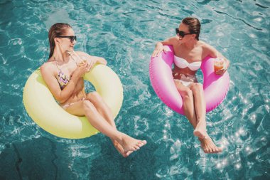 Üstten görünüm. Yüzme havuzunda iki güzel kadın.
