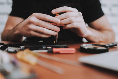 Kadar genç adam tamir cep telefonu masasında kapatın