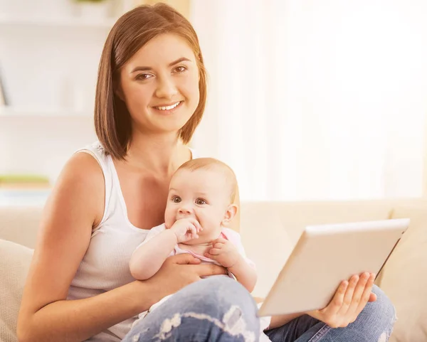 Lycklig mamma använda digitala surfplatta och hålla barnet — Stockfoto