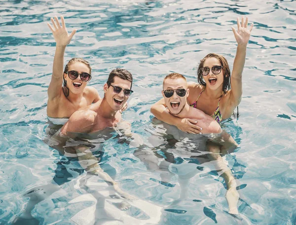 Hermosa gente joven divirtiéndose en la piscina — Foto de Stock