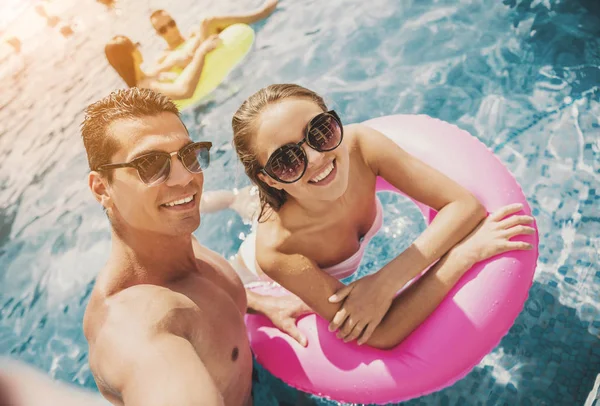 Jovem casal sorridente perto de piscina no verão . — Fotografia de Stock