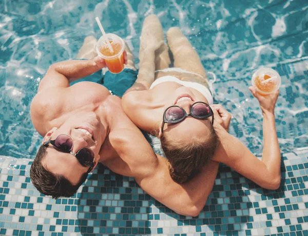 Üstten görünüm. Yaz aylarında yüzme havuzunda gülümseyen çift. — Stok fotoğraf