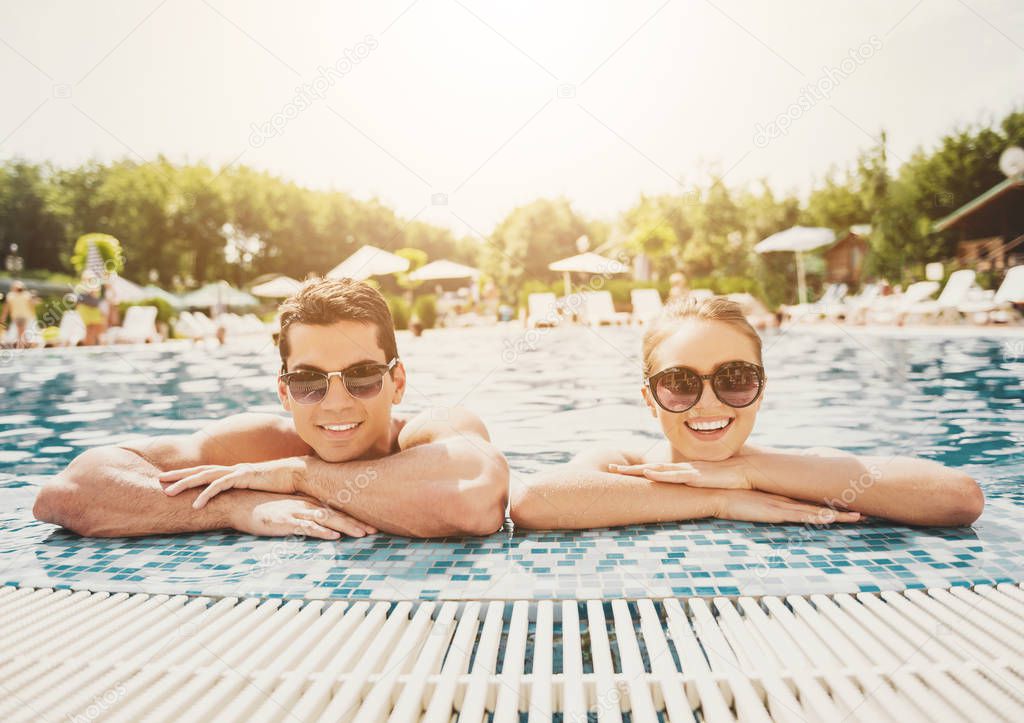 Young Smiling Couple in Swimming Pool in Summer.