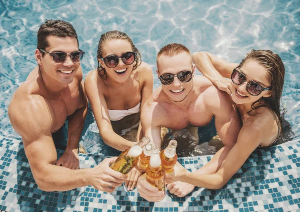 Belos jovens se divertindo na piscina — Fotografia de Stock