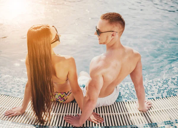 Lächelndes junges Paar im Sommer in Schwimmbadnähe. — Stockfoto