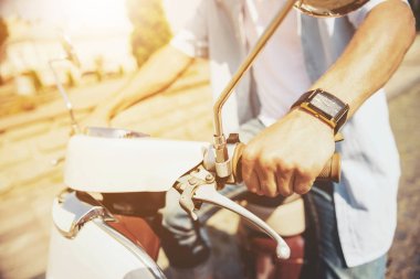 Yakın çekim. Scooter açık havada üzerinde oturan genç adam.