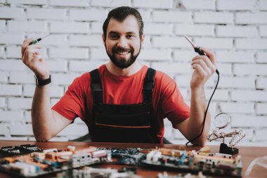 Dükkanda kırık anakartlar genç adam üniformalı. Modern atölye kavramı. Üretim aracı. Modern araçları kavramı. Elektronik cihazlar kavramı. Mobil aygıt donanım. Ahşap Resepsiyon.