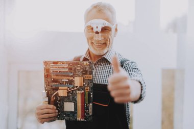 Eski işçi anakart ile el ayakta. Alt donanım ile. Modern atölye kavramı. Adam Modern aygıtları duran. Dijital aygıt. Elektronik cihazlar kavramı. Gözlüklü adam.