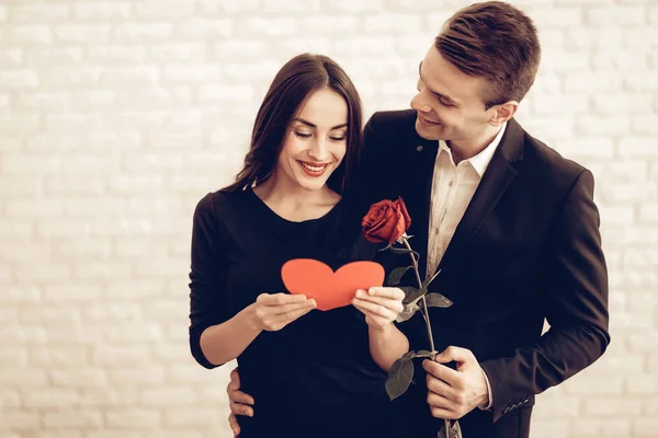 バラと赤のハートの折り紙をカップルします バレンタインの日 お互いが大好きです ロマンチックな休日 恋人の祭典のコンセプトです 若くてハンサムです 感情を示します 陽気な恋人 — ストック写真