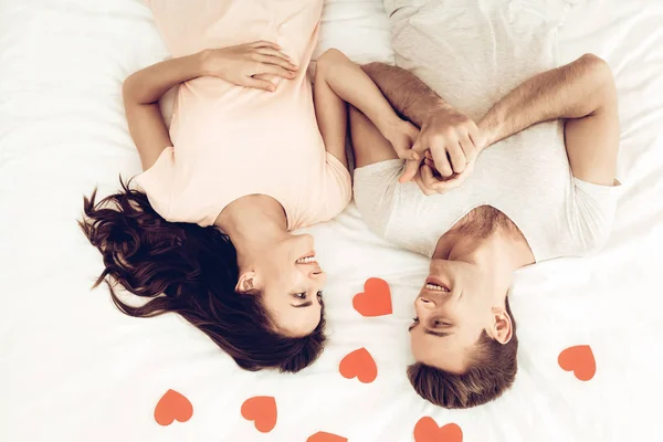 情人节那天幸福的情侣躺在床上 彼此相爱 甜心的节日概念 折纸玫瑰 庆祝日期 年轻又英俊 眼睛闭合的夫妇 快乐在一起 — 图库照片