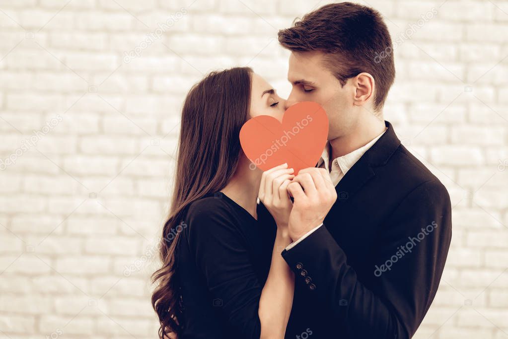 Happy Couple With Red Heart Origami. Valentine's Day. Love Each Other. Beautiful Holiday. Sweetheart's Celebration Concept. Young And Handsome. Feelings Showing. Cheerful Lovers. Romantic Kiss.
