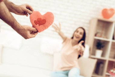 Adam kız arkadaşına Sevgililer Günü'nde bir hediye olur. Birbirimizi seviyoruz. Sevgilinin romantik tatil kavramı. Genç ve yakışıklı. Mutlu ilişki. Yastık kalp Holding. Mevcut açılış.