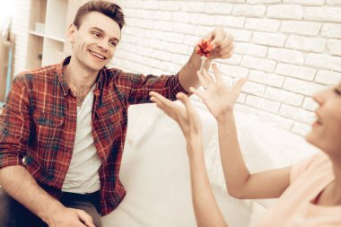 Adam kız arkadaşına Sevgililer Günü'nde bir hediye olur. Birbirimizi seviyoruz. Sevgilinin romantik tatil kavramı. Çift hediye sunma. Mutlu ilişki. Gösterilen duygular. Kalp anahtarından.