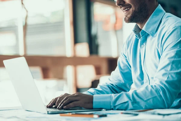 Ofiste çalışan gülümseyen genç iş adamı. Dizüstü bilgisayar ofiste. Bristle 'ın Masada Oturduğu ve Bilgisayarda Çalışırken Mutlu Adam' a yaklaş. Adam işten zevk alıyor. Kurumsal Yaşam Tarzı Konsepti