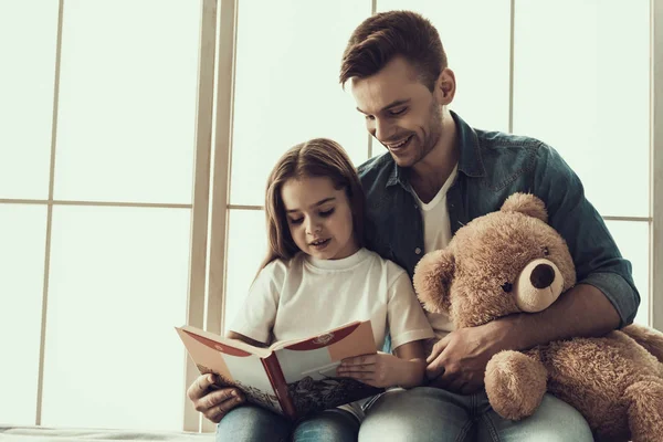 Νεαρός Χαμογελαστός Άντρας Διαβάζει Βιβλίο Στο Κοριτσάκι Ευτυχισμένος Όμορφος Πατέρας — Φωτογραφία Αρχείου