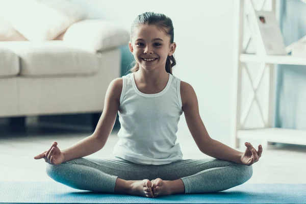 Smiling Little Girl doing Yoga Pose at Home. Adorable Happy Child in Sportswear Sitting on Yaga mat in Yoga Pose. Cute Little Girl having Fun doing Exercises at Home. Healthy Lifestyle — Stock Image Smiling Little Girl Doing Yoga Pose Home Adorable Happy Child Royalty Free Stock Images