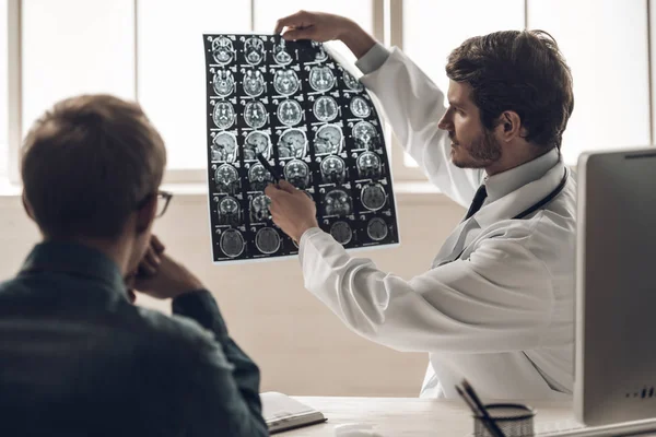 Jovem Médico Mostrando Ressonância Magnética Cérebro Para Paciente Jovem Bonito — Fotografia de Stock