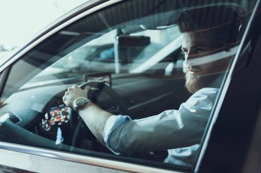 Kapalı Pencereli Direksiyon Hakimiyetini Tutan Buisiness Man Driving Car Close-Up Portre. Siyah Takım Elbiseli Güçlü Sakallı Kafkas Buisiness Man Yolu Izliyor. Otomatik Sürüş Konsepti