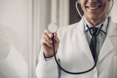 Mutlu Doktor Steteskop'u tutuyor. Sağlık Kavramı. Beyaz Laboratuvar Önlüğü Giyen Beyaz Laboratuvar Önlüğü Giyen Beyaz Yetişkin Tıp İşçisi Neşeli Bir İfadeyle Poz Verirken. Çocuk Doktoru Mesleği