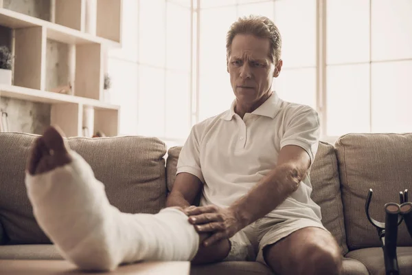 Kanepede Oturan Kırık Bacaklı Adamın Portresi Yakışıklı Kafkas Adam Beyaz — Stok fotoğraf