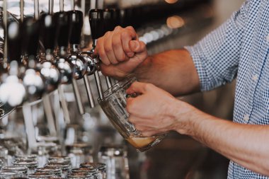 Barmen In Tap Lager Bira Dökme Close Up. Müşteriye Bira Döküyorum. Bar Kontuvarında Dururken Genç BarmenIn Bira Dökmesinin Yan Görünümü.