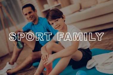 Baba ve oğul spor salonu halı üzerinde dinlenme. Sağlıklı bir yaşam tarzı. Aktif tatil. Spor kıyafetler. Evde çalışma dışarı. Su şişesi. Vücut egzersizleri. Aile eğitim gün kavramı.