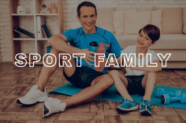 Baba ve oğul spor salonu halı üzerinde dinlenme. Sağlıklı bir yaşam tarzı. Aktif tatil. Spor kıyafetler. Evde çalışma dışarı. Su şişesi. Vücut egzersizleri. Aile eğitim gün kavramı.