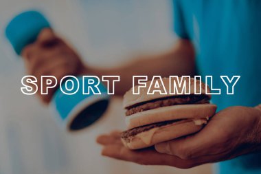 Bir Adam Her Elinde Dumbell ve Burger ile Duruyor. Kendi kararını ver. Junkfood Beslenme. Doğru seçim. Diyet Kavramı. Sağlıklı yaşam tarzı. Egzersiz. İki yol. Kolesterol Gıda.